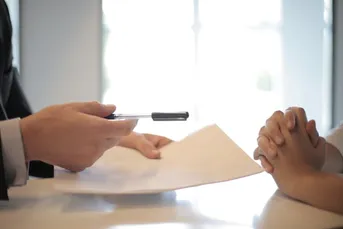 Hands across a table in meeting.